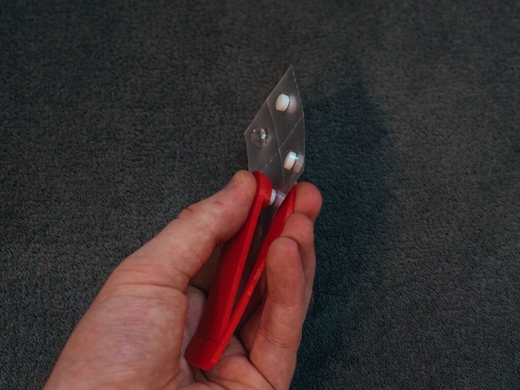 Side-view of EasyPill being used to take out a small pill